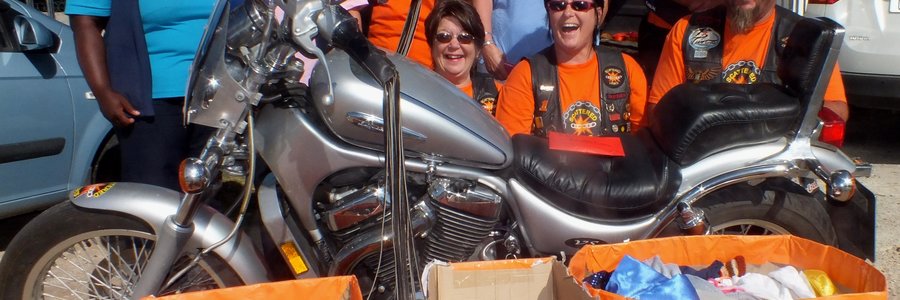  Die Scattered Links, Overberg Chapter se Gansbaai Motorfiets-tak, tydens die oorhandiging van donasies aan Gansbaai Elim Huis, met agter vlnr Sanna Wessels, Joanne Swart, Wilma van der Merwe, Sonja van Straten, Hansie van der Merwe, Gail Marais en Juanita en Pieter Maree 